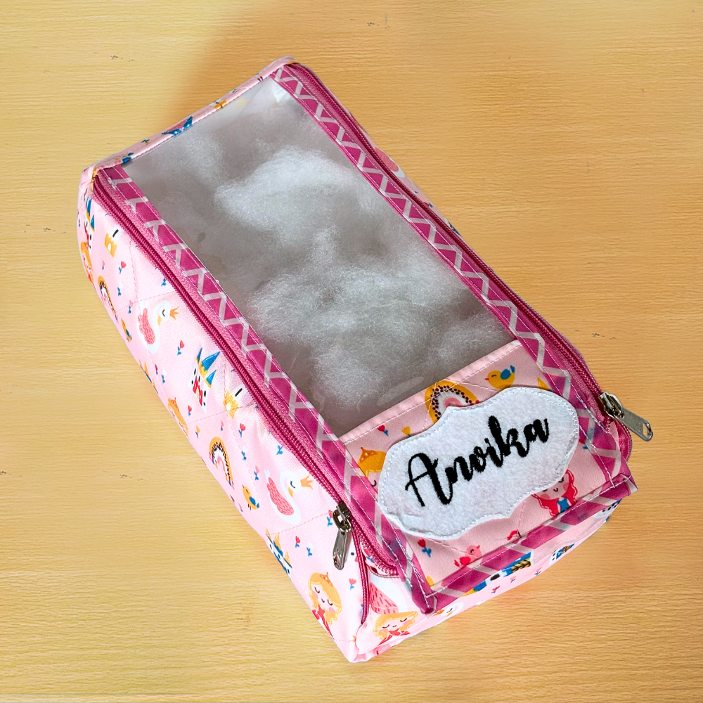 Pink pencil case with colorful patterns and a name tag