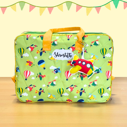 Green suitcase with airplane pattern